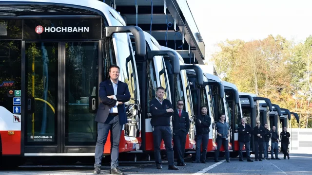 Zehn elektrische HOCHBAHN Linienbusse unter einem Carport am Busbetriebshof Alsterdorf; vor jedem steht eine Fahrerin oder ein Fahrer. © HOCHBAHN Zehn elektrische HOCHBAHN Linienbusse unter einem Carport am Busbetriebshof Alsterdorf; vor jedem Bus steht eine Fahrerin oder ein Fahrer.