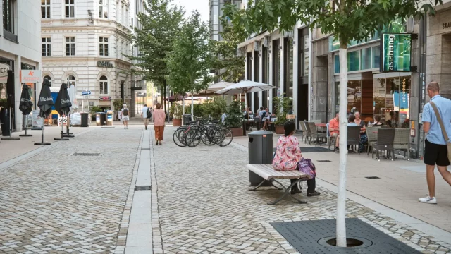 Neu gestaltetes, autofreies Rathausquartier: Menschen sitzen in Cafés und genießen den öffentlichen Raum. © BVM / Robin Lindner Neu gestaltetes, autofreies Rathausquartier mit Außengastronomie; Menschen sitzen in Cafés.
